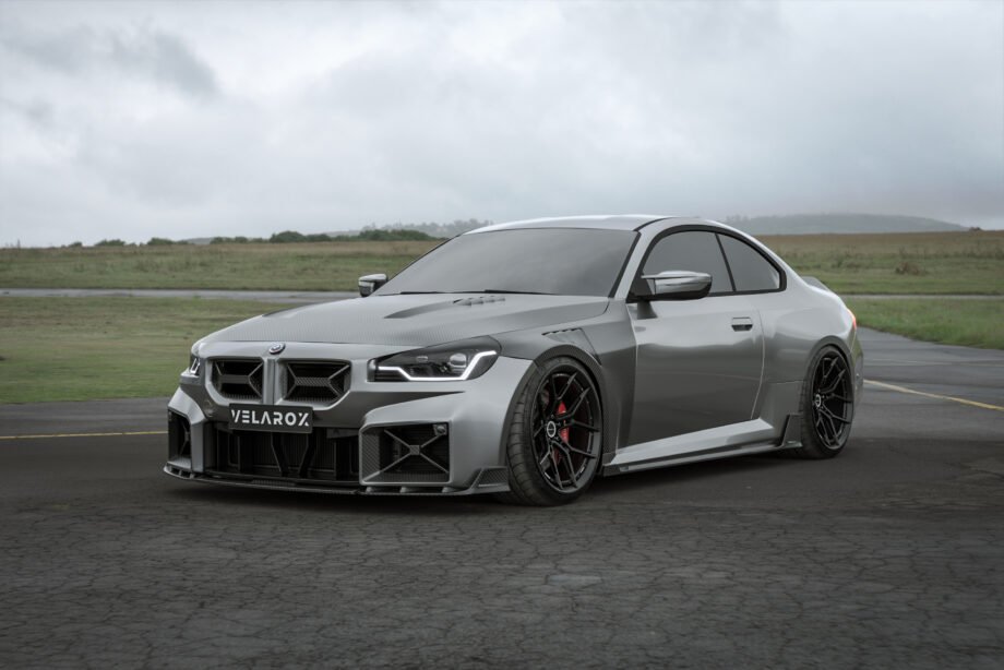 BMW M2 G87 with full dry carbon fiber body kit including front lip, side skirts, hood, and rear spoiler parked in an outdoor setting