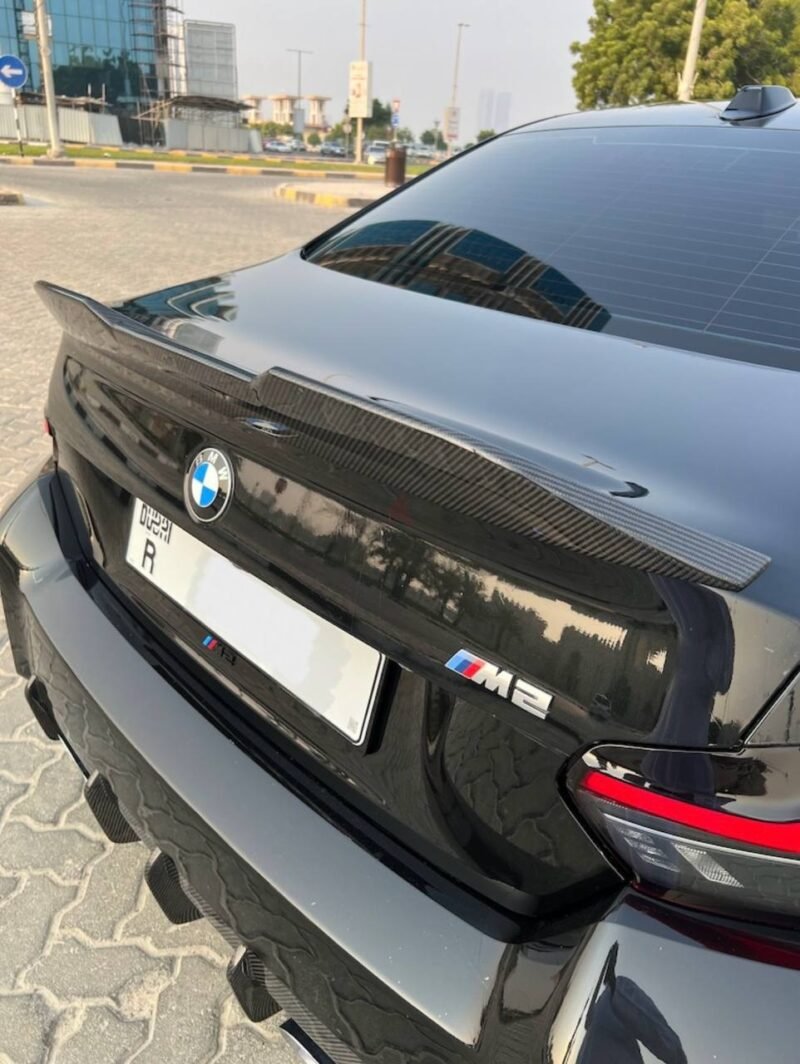 BMW M2 G87 with installed dry carbon fiber rear spoiler for improved aerodynamic performance and lightweight styling
