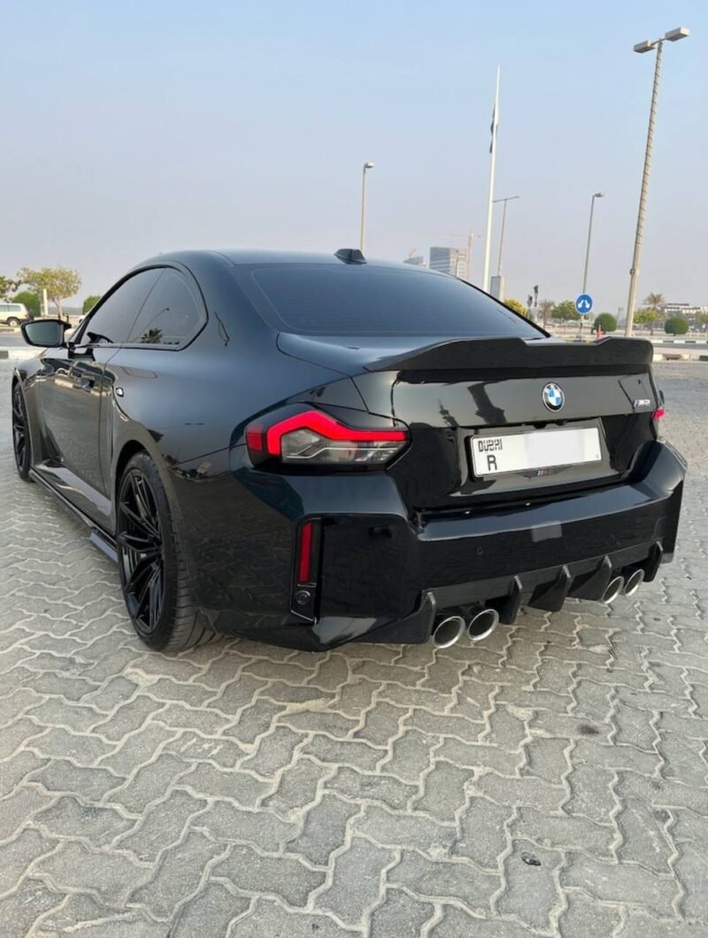 BMW M2 G87 with installed dry carbon fiber rear spoiler for improved aerodynamic performance and lightweight styling
